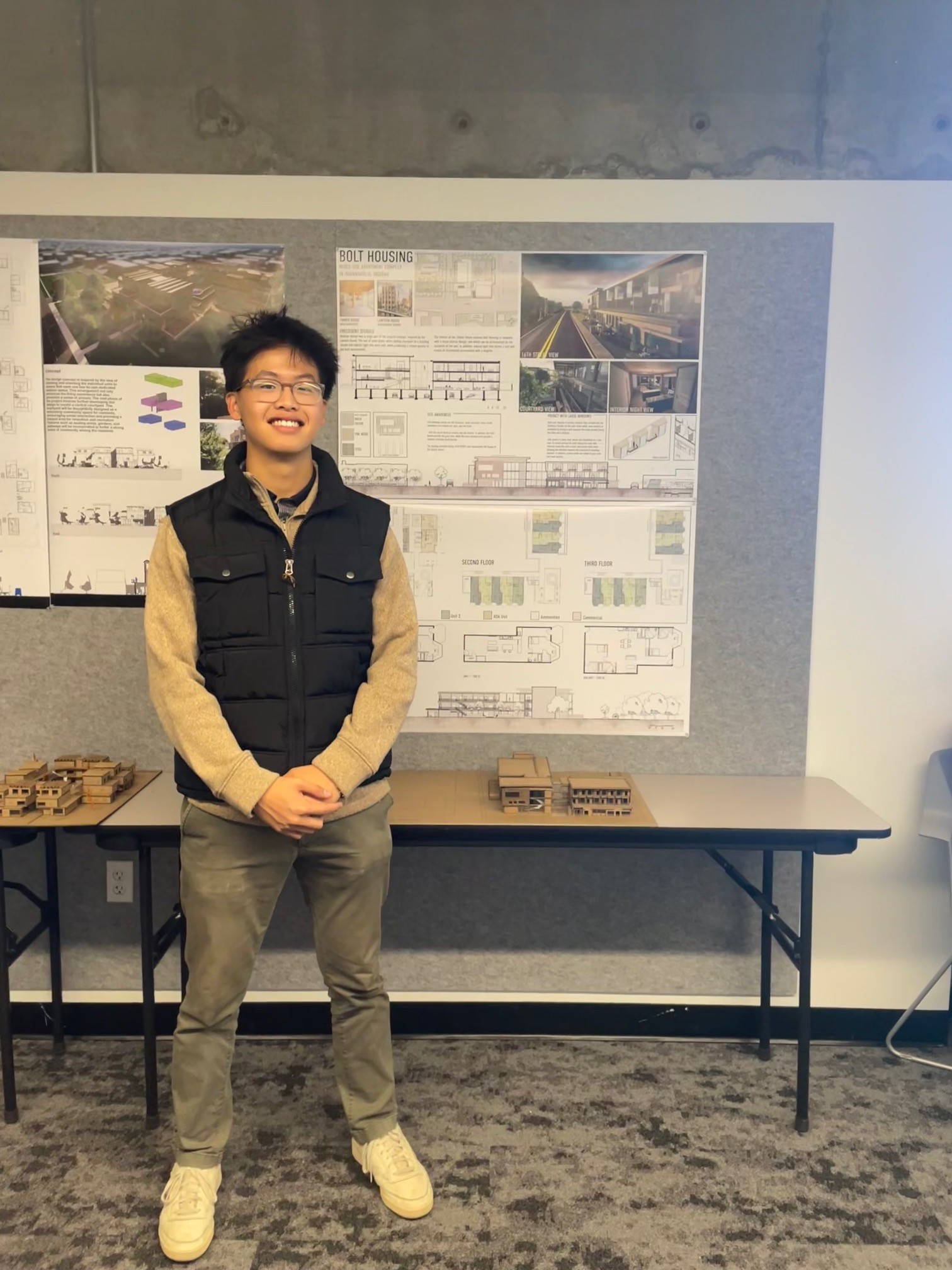 Dylan Fujii with his architecture portfolio and models